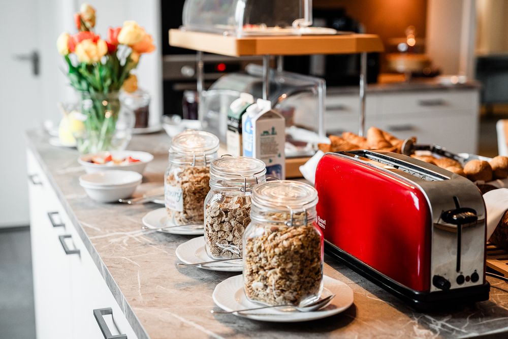 Het ontbijtbuffet met verschillende ontbijtgranen, yoghurt, melk, vers fruit en de broodrooster.